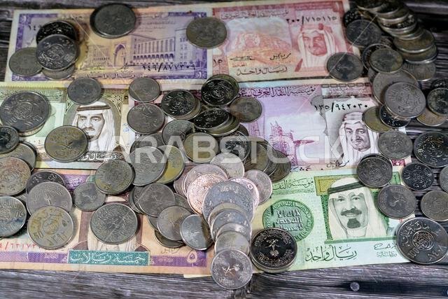 Saudi Arabia riyals money banknote bills and coins of different eras from the kingdom of Saudi Arabia times, vintage retro old Saudi currency, value,