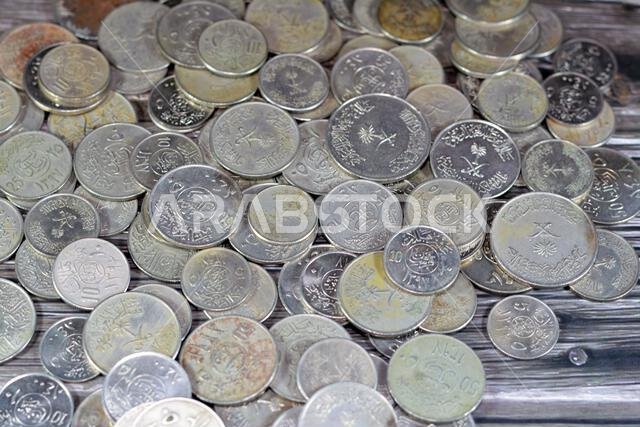 Old Saudi Arabia money coins of different eras from the kingdom of Saudi Arabia times, vintage retro old Saudi currency, value, exchange rate of the c
