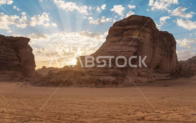 تشرق شمس الصباح على التكوينات الصخرية الصحراوية، وهو مشهد نموذجي في العلا، المملكة العربية السعودية