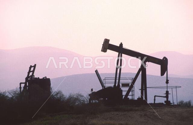 The change in oil prices caused by the war. Oil price cap concept. Oil drilling derricks at desert oilfield. Crude oil production from the ground. Pet