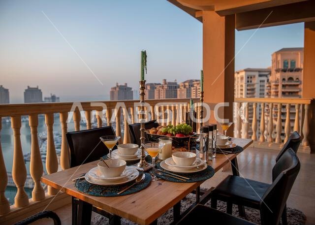 Dinner table at rooftop with sunset view at pearl Qatar.  view of Peral Qatar Porto Arabia from Balcony