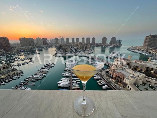 طاولة عشاء على سطح مبنى اللؤلؤة قطر مع إطلالة على غروب الشمس. إطلالة على ميناء اللؤلؤة قطر من الشرفة. طاولة عشاء على سطح مبنى اللؤلؤة قطر مع إطلالة على غروب الشمس. إطلالة على ميناء اللؤلؤة قطر من الشرفة.