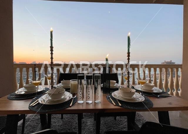 Dinner table at rooftop with sunset view at pearl Qatar.  view of Peral Qatar Porto Arabia from Balcony
