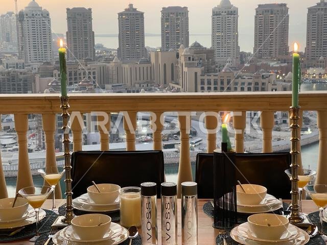 طاولة عشاء على سطح مبنى اللؤلؤة قطر مع إطلالة على غروب الشمس. إطلالة على ميناء اللؤلؤة قطر من الشرفة. طاولة عشاء على سطح مبنى اللؤلؤة قطر مع إطلالة على غروب الشمس. إطلالة على ميناء اللؤلؤة قطر من الشرفة.