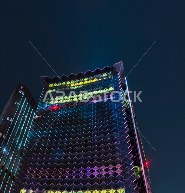 صورة ابداعية لمركز الملك عبدالله المالي ( كافد ) في الرياض بالمملكة العربية السعودية ليلا، معالم الرياض المشهورة، ابراج وناطحات سحاب مضيئة، الفن الهندسي المعماري بالسعودية، السياحة في السعودية