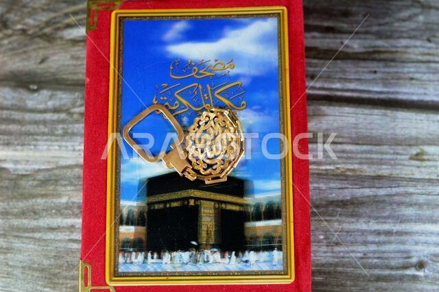 Makkah al-Mukarramah or Mecca the honored Quran, with blurry glowing picture of Kaaba, with a Golden keyring medal, Translation of Arabic (God is the Makkah al-Mukarramah or Mecca the honored Quran, with blurry glowing picture of Kaaba, with a Golden keyring medal, Translation of Arabic (God is the