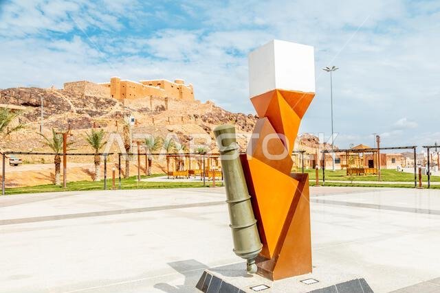 نصب تذكاري للمدفع مع قلعة العارفين العربية القائمة على التل، حائل، المملكة العربية السعودية