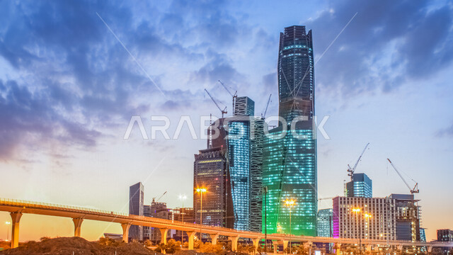 صورة ابداعية لمركز الملك عبدالله المالي ( كافد ) في الرياض بالمملكة العربية السعودية بعد الغروب، أبراج وناطحات سحاب مضيئة، معالم الرياض المشهورة، الفن الهندسي المعماري بالسعودية، السياحة في السعودية