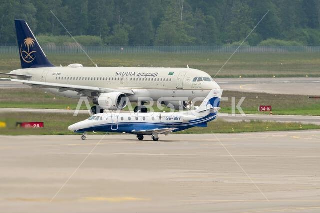 Zurich, Switzerland, May 19, 2023 HZ-ASB Saudi Arabian Airlines Airbus A320-214 is taking off from runway 10 behind an Air Adriatic Cessna Citation 56