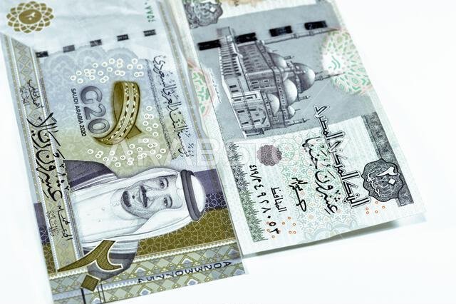 ورقة نقدية سعودية من فئة 20 ريالاً سعودياً، مع 20 جنيهاً مصرياً، وسعر صرف العملات المصرية والسعودية، وصورة لمسجد محمد علي.
