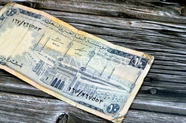 obverse side of 10 SAR Saudi Arabia riyals cash money currency banknote features Al-Masjid al-Haram (Holy mosque), Mecca, vintage retro old 10 riyals, obverse side of 10 SAR Saudi Arabia riyals cash money currency banknote features Al-Masjid al-Haram (Holy mosque), Mecca, vintage retro old 10 riyals,