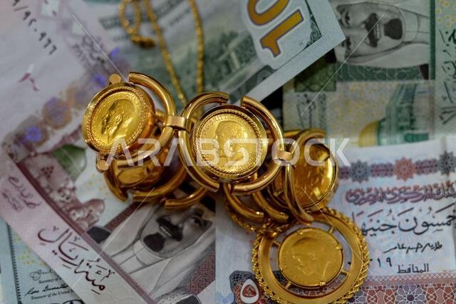 عملات ورقية من الدولار الأمريكي والجنيه المصري والريال السعودي، بالإضافة إلى عملات ذهبية بريطانية ذات أشكال مميزة. عملات ورقية من الدولار الأمريكي والجنيه المصري والريال السعودي، بالإضافة إلى عملات ذهبية بريطانية ذات أشكال مميزة.