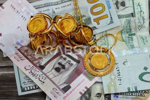 Saudi Arabia Riyals and USA USD American dollars banknotes currency bills money with sovereign British gold coins shapes bullion coin features George