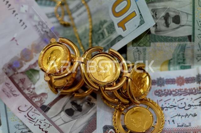 American dollars, Egyptian pounds and Saudi Arabia Riyals banknotes currency bills money with sovereign British gold coins shapes bullion coin feature