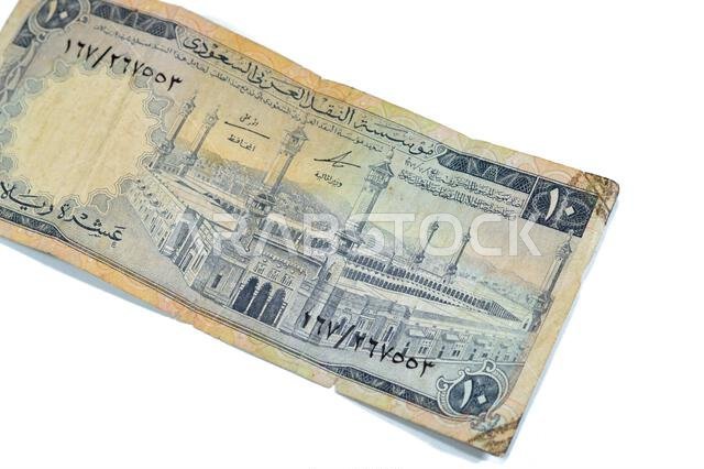 يُظهر الوجه الأمامي للورقة النقدية من فئة 10 ريالات سعودية المسجد الحرام (المسجد الحرام)، مكة المكرمة، وهي ورقة نقدية قديمة الطراز من فئة 10 ريالات.