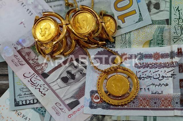 عملات ورقية من الدولار الأمريكي والجنيه المصري والريال السعودي، بالإضافة إلى عملات ذهبية بريطانية ذات أشكال مميزة.