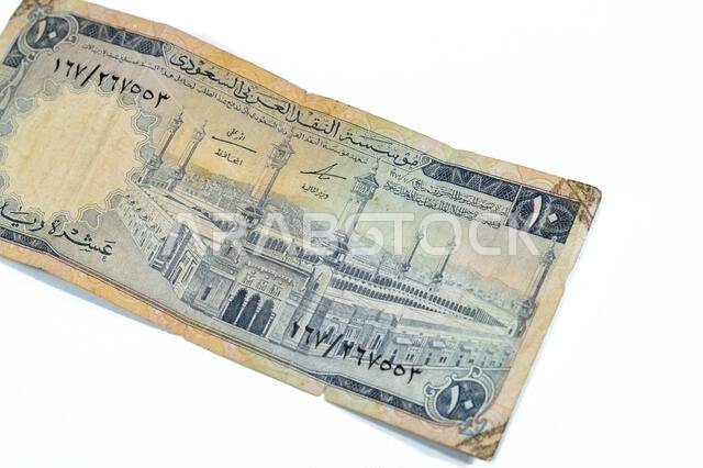 يُظهر الوجه الأمامي للورقة النقدية من فئة 10 ريالات سعودية المسجد الحرام (المسجد الحرام)، مكة المكرمة، وهي ورقة نقدية قديمة الطراز من فئة 10 ريالات.