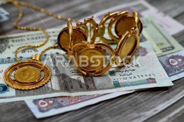 American dollars, Egyptian pounds and Saudi Arabia Riyals banknotes currency bills money with sovereign British gold coins shapes bullion coin feature