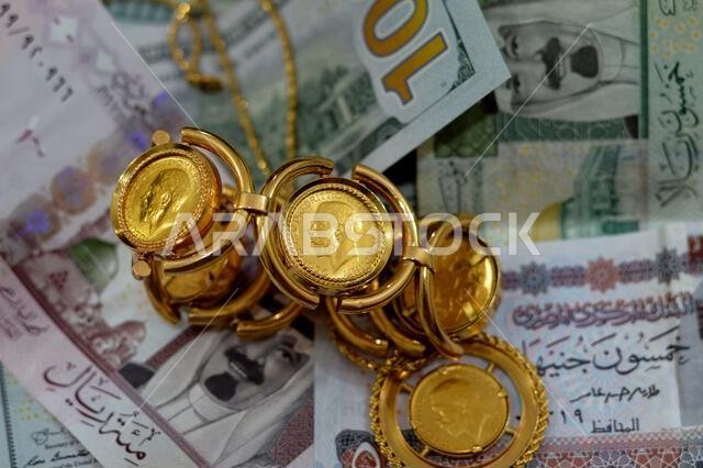 عملات ورقية من الدولار الأمريكي والجنيه المصري والريال السعودي، بالإضافة إلى عملات ذهبية بريطانية ذات أشكال مميزة.