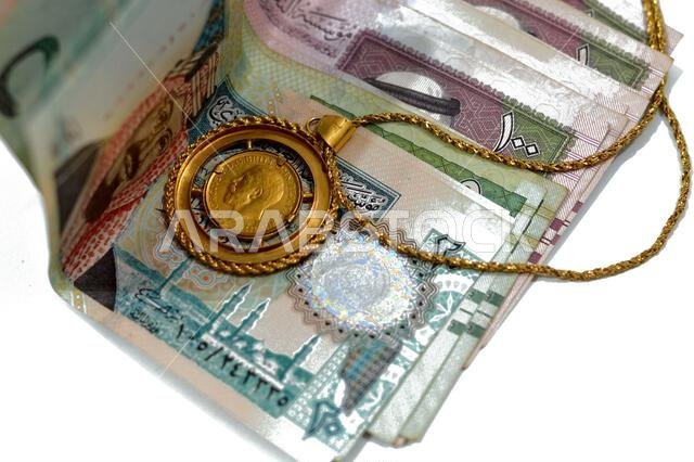 sovereign British gold coin shapes bullion coin features George and dragon Jewellery or jewelry on Saudi Arabia riyals cash money banknote, Gold price