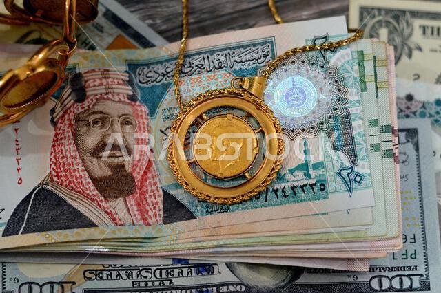 American dollars, Egyptian pounds and Saudi Arabia Riyals banknotes currency bills money with sovereign British gold coins shapes bullion coin feature