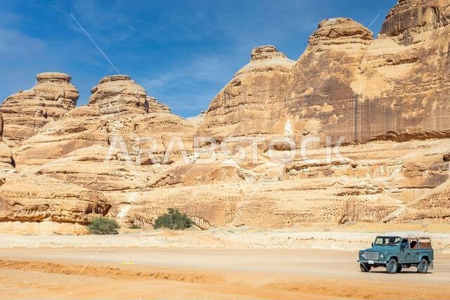 Off-road car and desert cliffs formations landscape at Hegra, Al Ula, Saudi Arabia