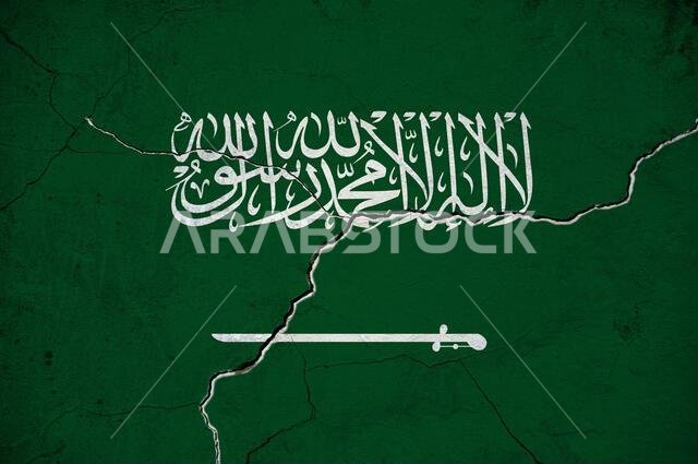 An image of the Saudi Arabia flag on a wall with a crack.
