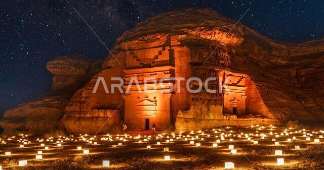 المقابر القديمة المحروسة لمدينة الحِجر النبطية مدائن صالح مضاءة أثناء الليل، العلا، المملكة العربية السعودية