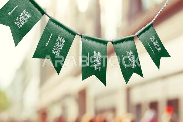 إكليل من أعلام المملكة العربية السعودية على خلفية ضبابية مجردة
