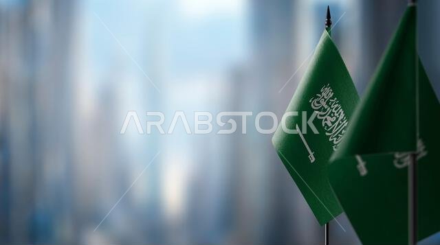 Small flags of the Saudi Arabia on an abstract blurry background