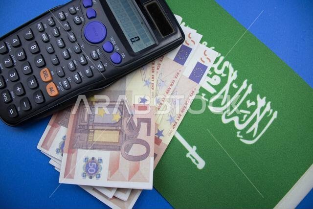 اليورو وآلة حاسبة موضوعة على العلم السعودي