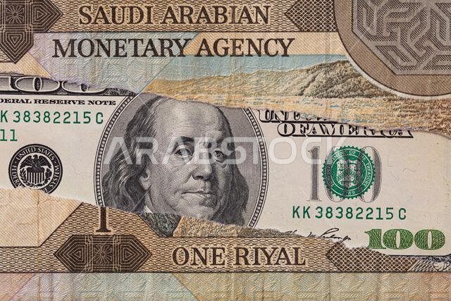 100 dollar banknote through torn  Saudi riyal banknote for design purpose