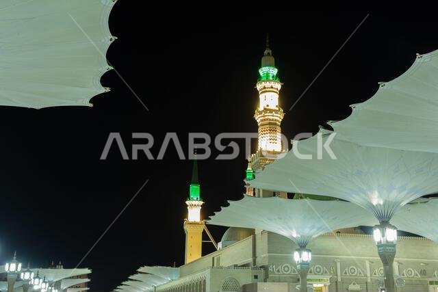 مآذن المسجد النبوي مع مظلات في المقدمة، المدينة المنورة، المملكة العربية السعودية مآذن المسجد النبوي مع مظلات في المقدمة، المدينة المنورة، المملكة العربية السعودية