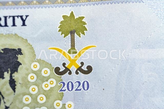 Saudi Arabian emblem from everse side of 20 SAR twenty Saudi Arabia Riyals banknote currency bill money Commemorative issue with a map of the world de