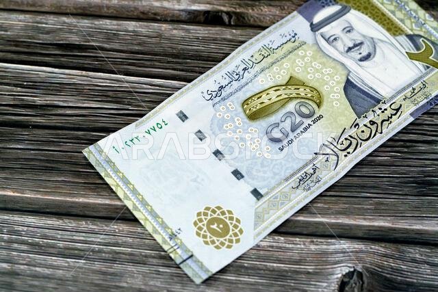 الوجه الأمامي لفئة 20 ريال سعودي، وهي عملة تذكارية تحمل صورة الملك سلمان وشعار الملك ثلاثي الأبعاد.
