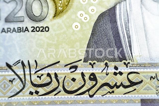 ترجمة كلمة "عشرون ريالاً" من الوجه الخلفي لفئة العشرين ريالاً سعودياً، وهي عملة تذكارية ثلاثية الأبعاد.