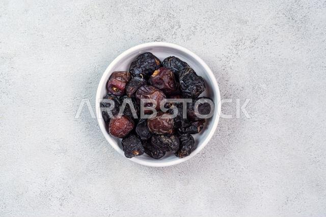 Raw Organic Arabic Dates, Ajwa Dates on light gray background. Ramadan Kareem. Close up.