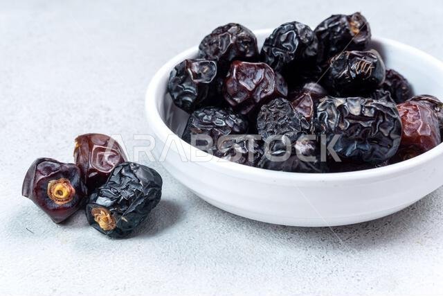 Raw Organic Arabic Dates, Ajwa Dates on light gray background. Ramadan Kareem. Close up.
