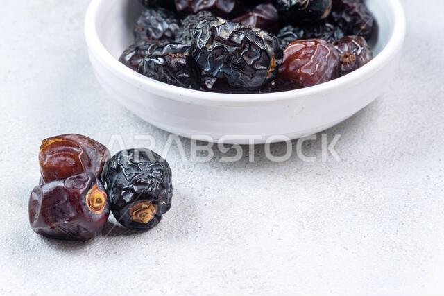 Raw Organic Arabic Dates, Ajwa Dates on light gray background. Ramadan Kareem. Close up.