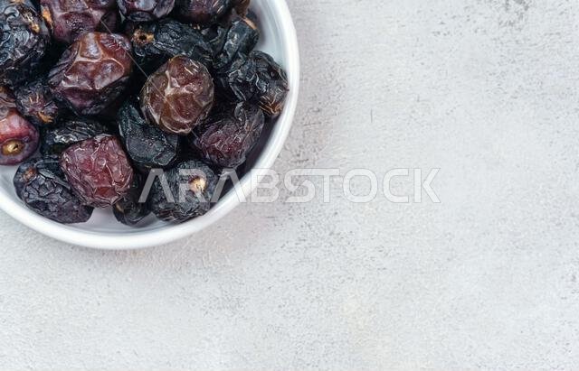 Raw Organic Arabic Dates, Ajwa Dates on light gray background. Ramadan Kareem. Close up.