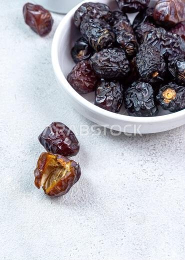 Raw Organic Arabic Dates, Ajwa Dates on light gray background. Ramadan Kareem. Close up.