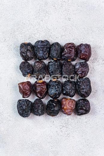 Raw Organic Arabic Dates, Ajwa Dates on light gray background. Ramadan Kareem. Close up.