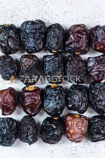 Raw Organic Arabic Dates, Ajwa Dates on light gray background. Ramadan Kareem. Close up.