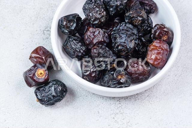 Raw Organic Arabic Dates, Ajwa Dates on light gray background. Ramadan Kareem. Close up.