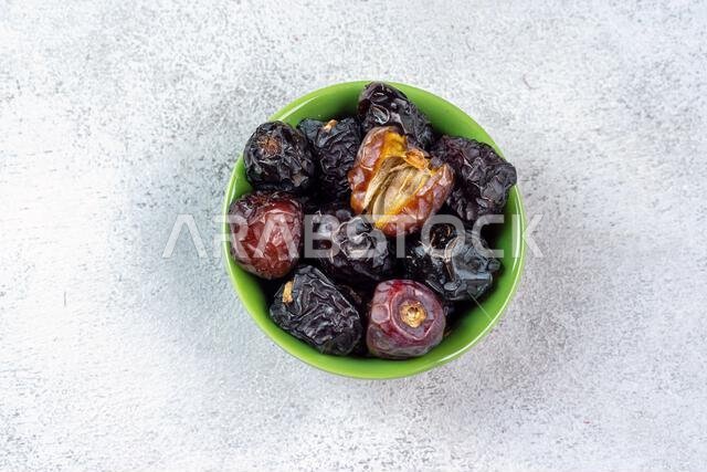 Raw Organic Arabic Dates, Ajwa Dates on light gray background. Ramadan Kareem. Close up.