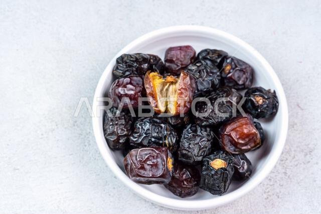 Raw Organic Arabic Dates, Ajwa Dates on light gray background. Ramadan Kareem. Close up.