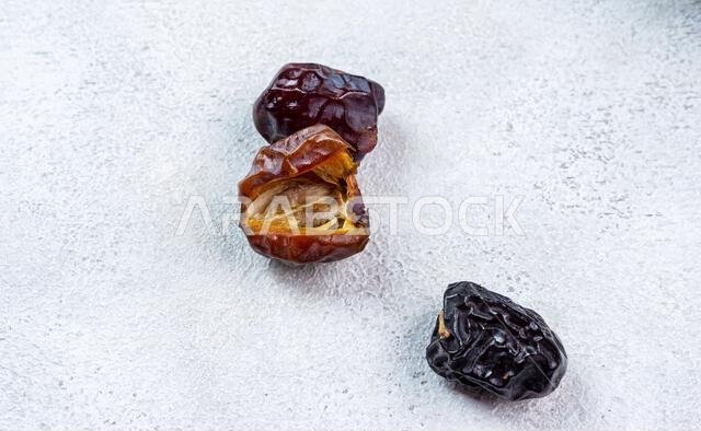Raw Organic Arabic Dates, Ajwa Dates on light gray background. Ramadan Kareem. Close up.