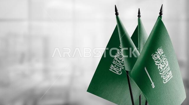 أعلام صغيرة للمملكة العربية السعودية على خلفية ضبابية مجردة