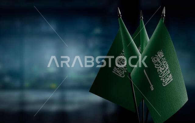 أعلام صغيرة للمملكة العربية السعودية على خلفية ضبابية مجردة