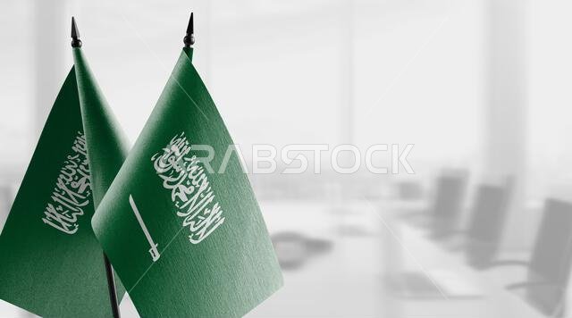 أعلام صغيرة للمملكة العربية السعودية على خلفية ضبابية مجردة